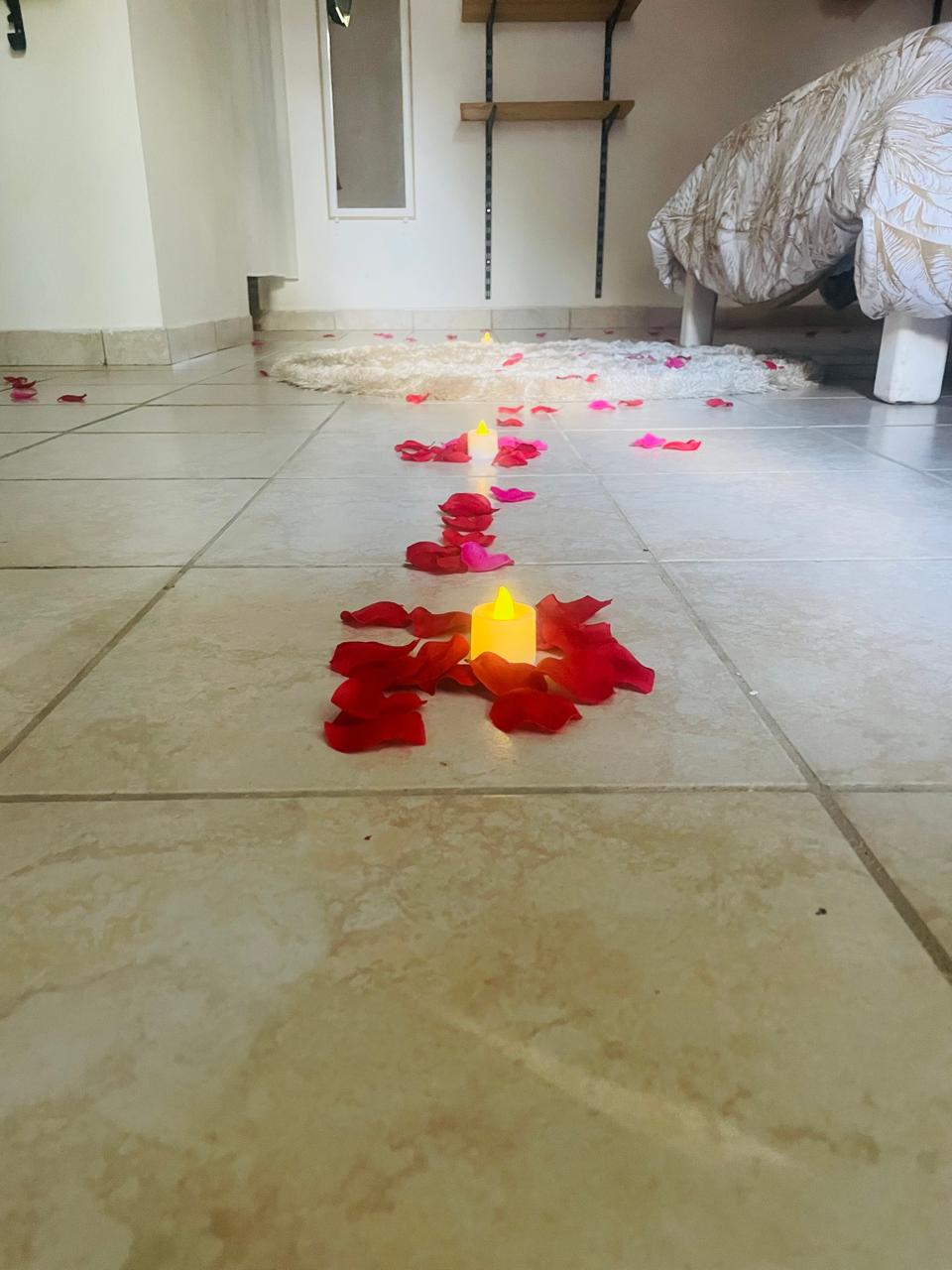 Vue large de la chambre mariage avec tapis rond et pétales