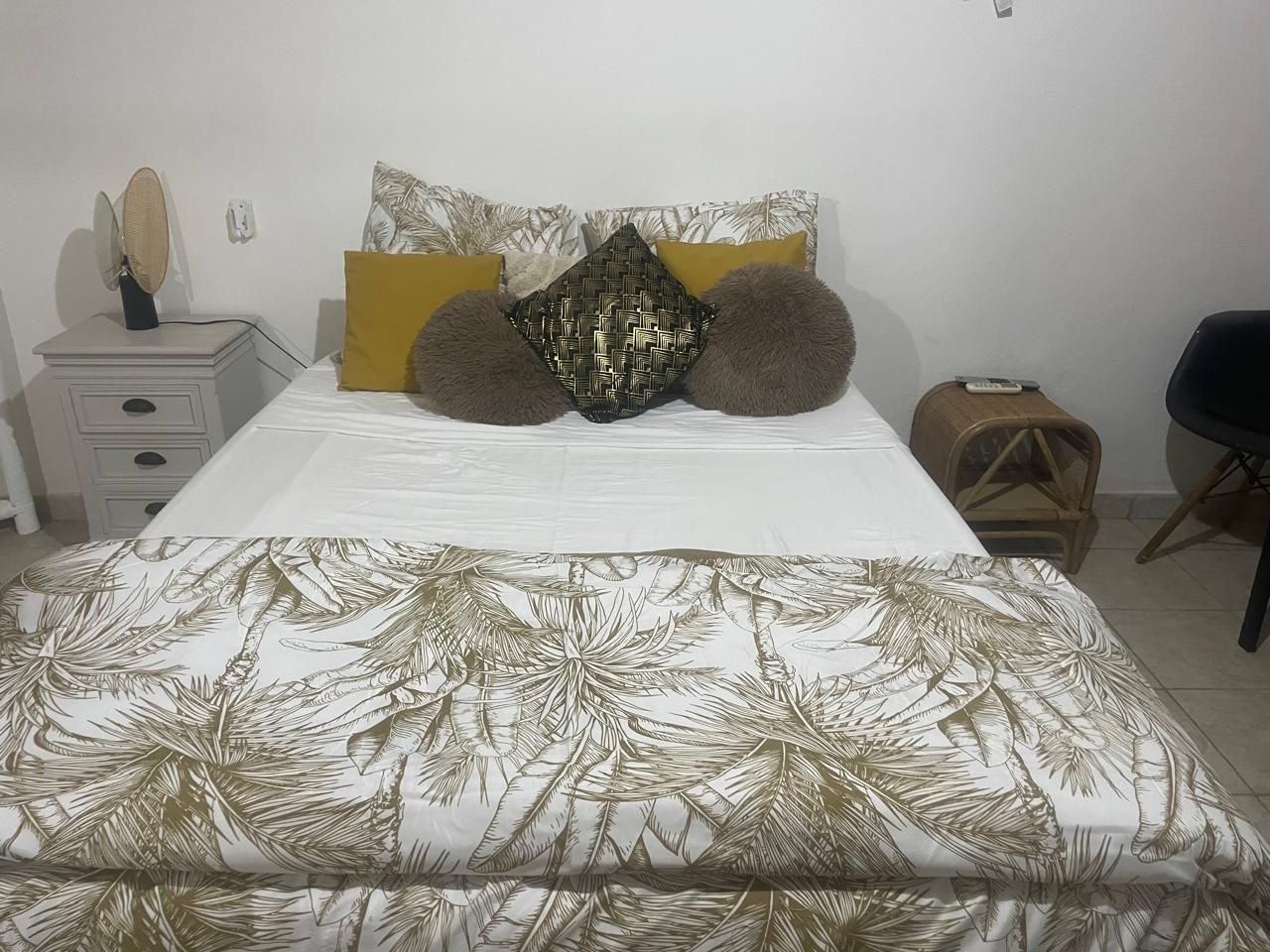 Chambre tropicale dorée — parure feuilles dorées et coussins jaunes