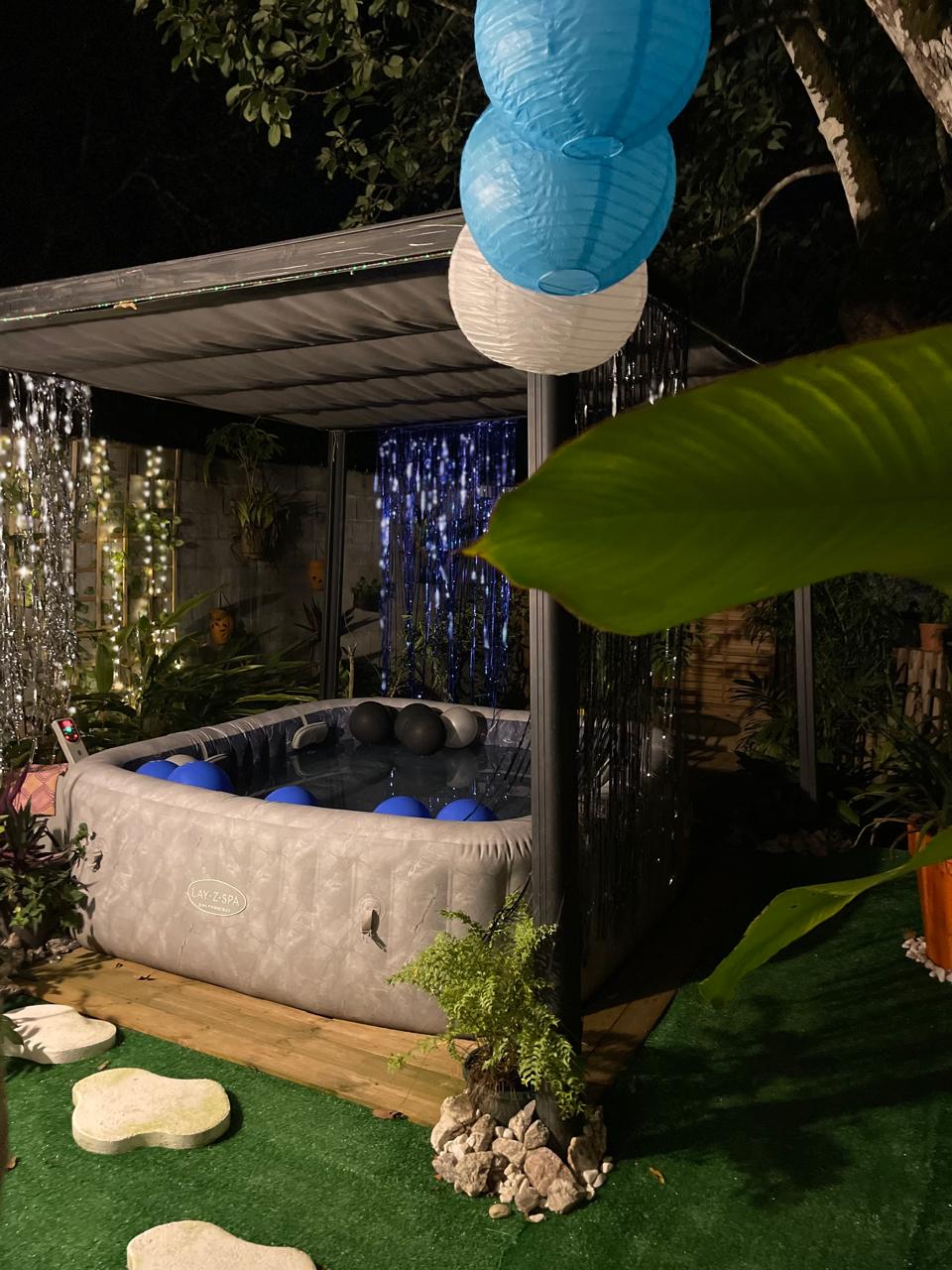 Jacuzzi de nuit avec lampions bleus et rideau scintillant