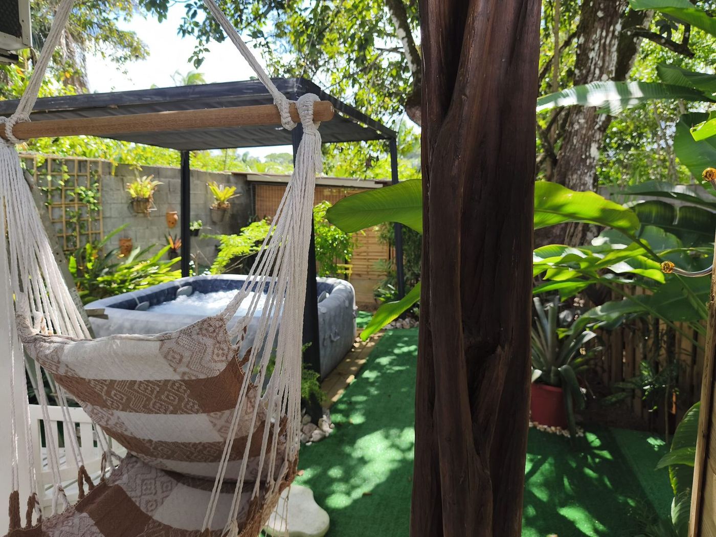 Hamac entre les arbres avec vue sur le jacuzzi